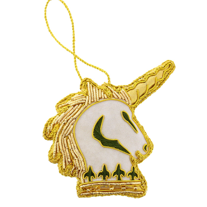 An embroidered unicorn head hanging decoration with a gold metallic border, a white face, green details, and a gold hanging loop. - Image