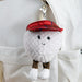 Plush keychain golf ball with a red hat attached to a white bag. - Image