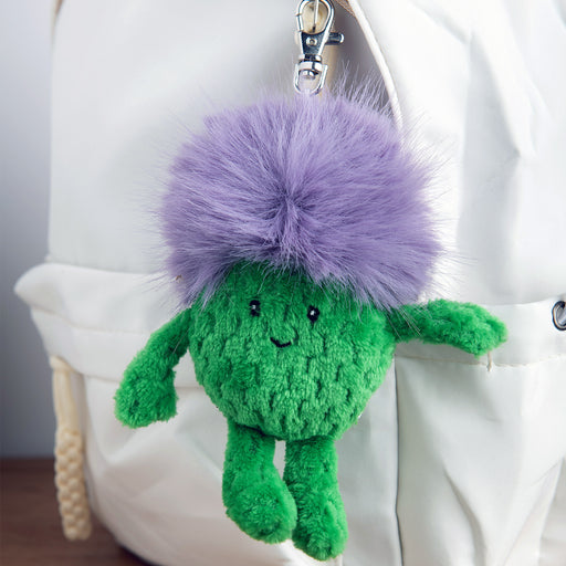 Green plush Thistle keychain attached to a white bag. - Image