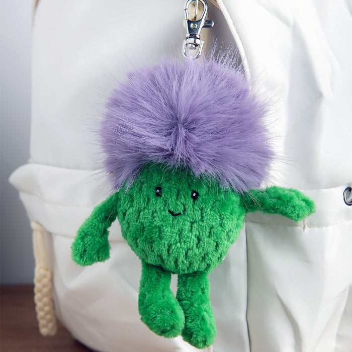 Green plush Thistle keychain attached to a white bag. - Image