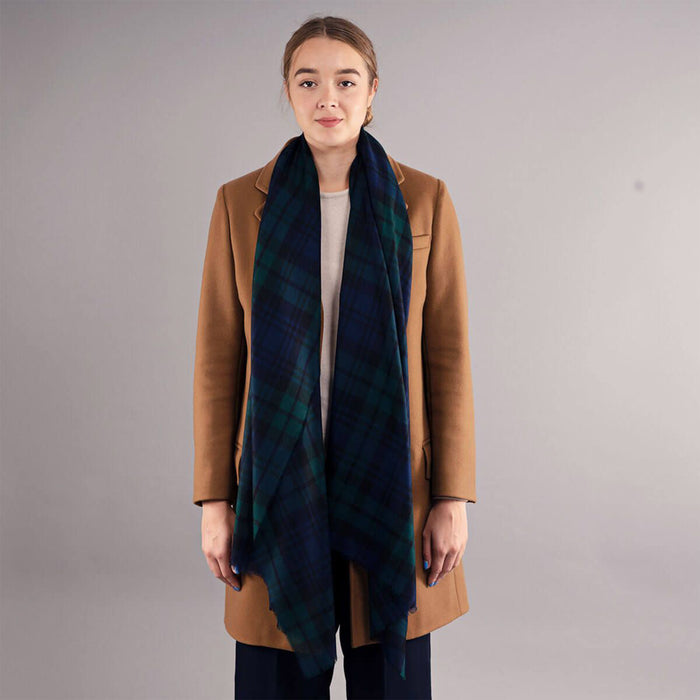 Woman wearing a brown coat and a dark green tartan scarf against a gray background - Image