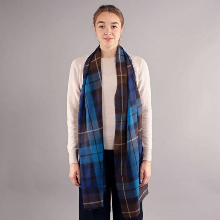 Person wearing a tartan scarf and beige sweater against a gray background - Image