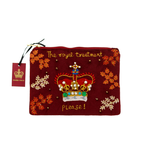 A rectangular burgundy velvet pouch with gold embroidered text reading 'The royal treatment please!' and a large embroidered crown motif in the center. The pouch is decorated with orange floral embroidery and small gold beads. - Image