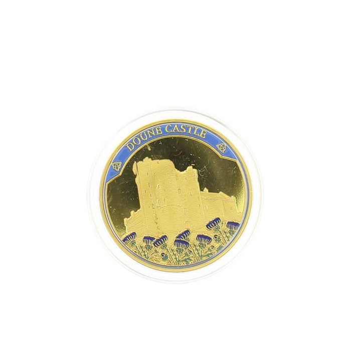 A circular gold-toned Doune Castle coin on a plain white background. - Image