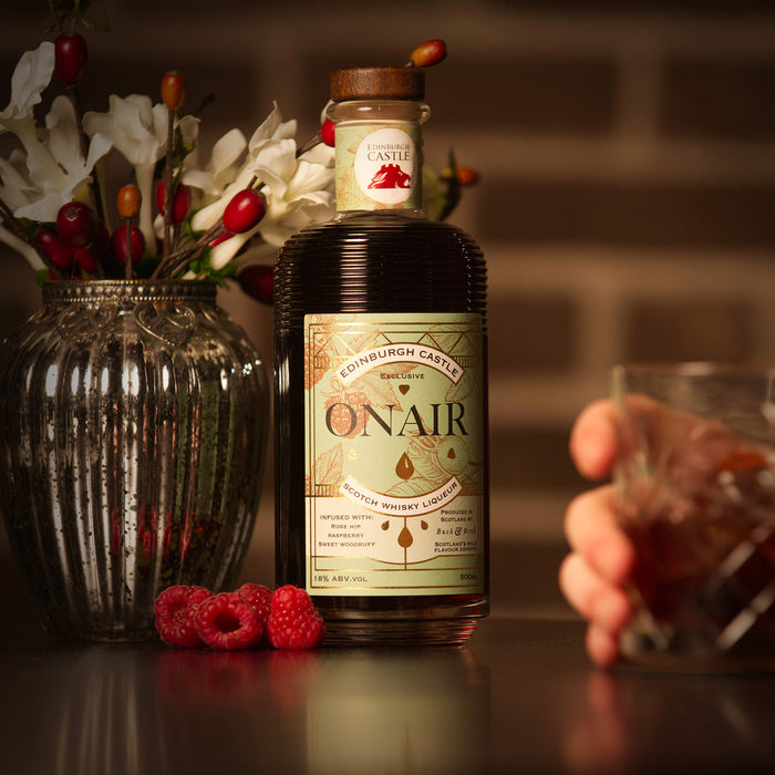 Onair whisky liqueur bottle with a glass and flowers on a table - Image