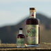 2 sizes of the whisky liqueur Onair' sit on a castle wall with Arthur's Seat in the distance.  - Image