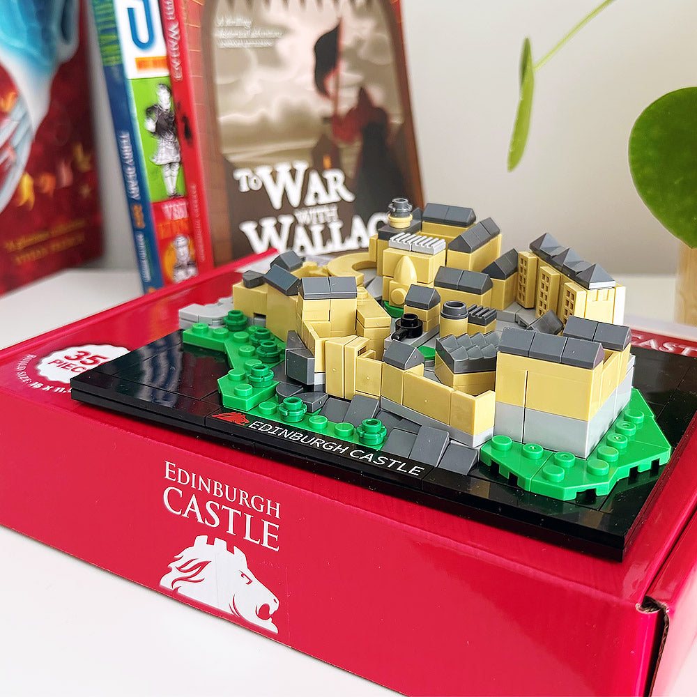 Model of Edinburgh Castle in a red box with books in the background - Image