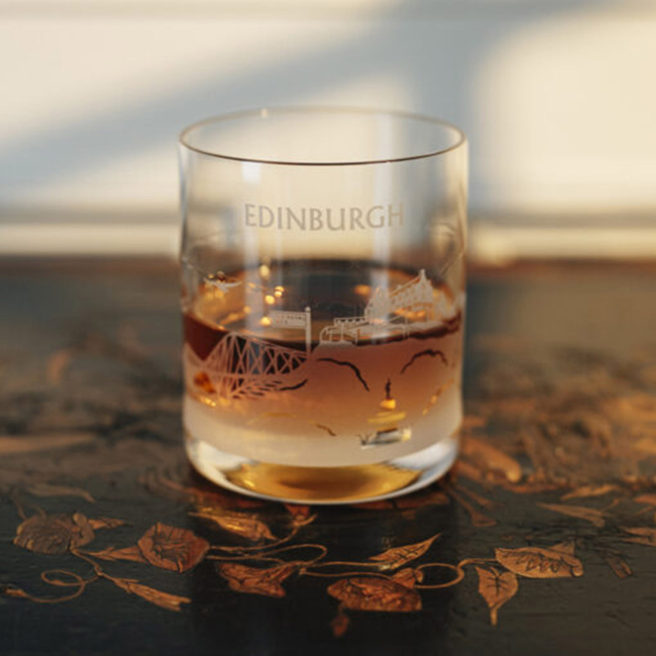 Glass with 'Edinburgh' engraving on a decorative table - Image