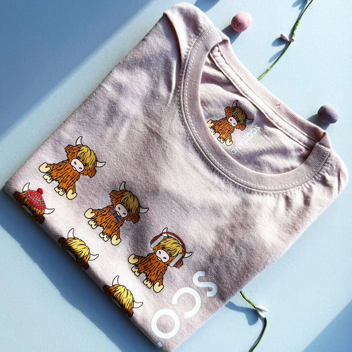 Folded pink t-shirt with Highland Calf design on a light blue background - Image