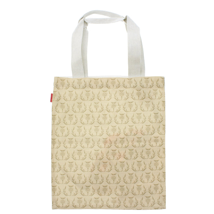 A canvas tote bag with white shoulder straps, featuring an all-over repeating pattern of Scottish Thistles in a muted gold-brown hue on a warm cream background. - Image