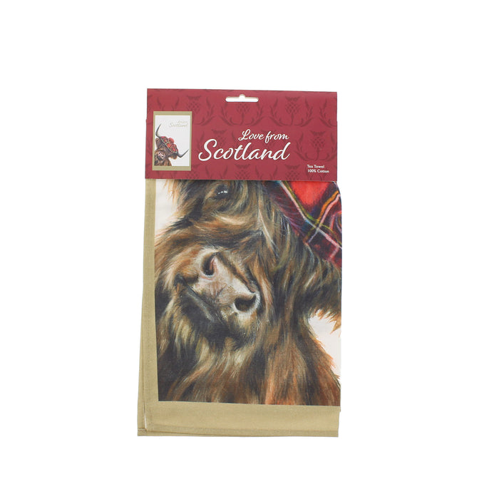 A packaged tea towel featuring a detailed illustration of a Highland cow with a red tartan bonnet, under a red header card that reads 'Love from Scotland'. - Image