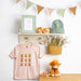 display of highland cow clothing and accessories against a white wall and shelf - Image