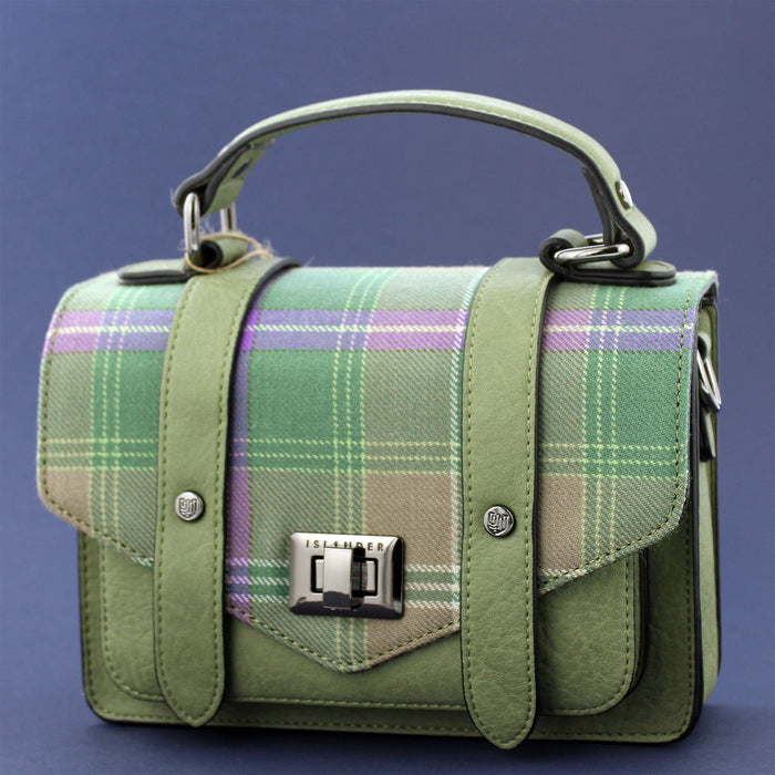 A green Bracken Tartan flap satchel style bag against a blue background. - Image