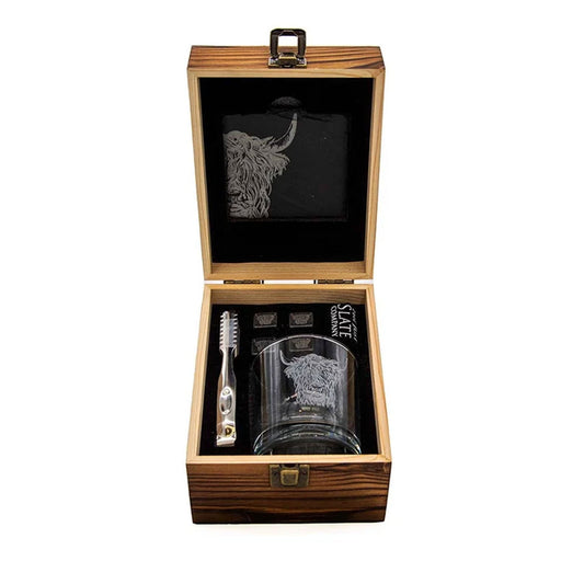 open wooden box featuring a glass with engraved highland cow, whisky stones, ice picker and a slate coaster. - Image