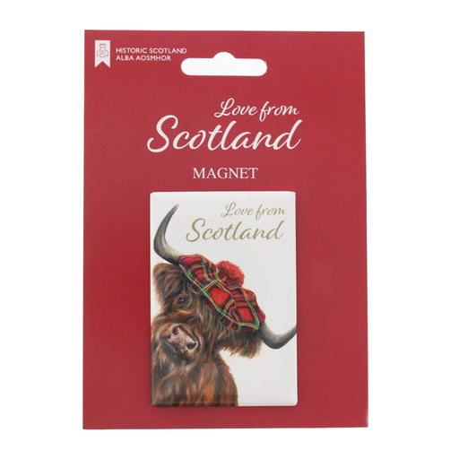 A rectangular Scotland magnet on red retail backing card. The magnet shows a highland cow wearing a red tartan hat, with the words 'Love from Scotland' above it. - Image