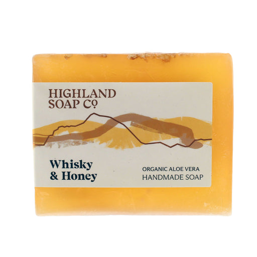 A rectangular bar of Highland Soap Co. Whisky & Honey handmade soap, featuring a warm amber-yellow color with visible honeycomb texture and embedded natural elements. - Image