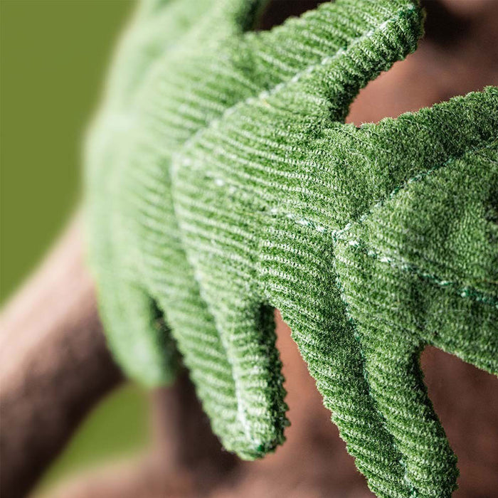 A close-up of a green textured gardening glove worn on a hand, showing the ribbed fabric and stitching, with a blurred green and brown background. - Image