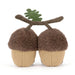 A pair of plush acorn-shaped slippers with fuzzy brown caps, beige textured bodies, brown stems, and a small green leaf on top, shown on a plain white background. - Image
