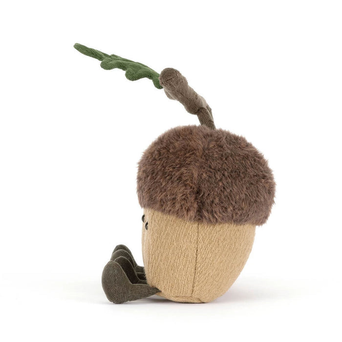 A plush acorn toy with a brown fuzzy cap, tan textured body, and green leaf on a stem, photographed on a clean white background. - Image