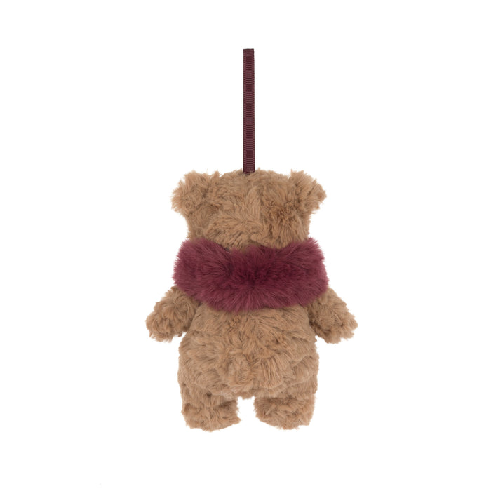 A small plush teddy bear hanging decoration shown from the back, with a tan body and a dark burgundy fuzzy scarf, suspended by a matching ribbon on a plain white background. - Image