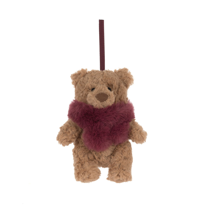 A small brown teddy bear decoration with a fuzzy dark burgundy scarf and a matching hanging ribbon, shown against a plain white background. - Image