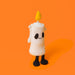 A cute, novelty plush toy shaped like a candle with a ribbed white body, black embroidered face, and black glittery feet, standing against a solid orange background. - Image