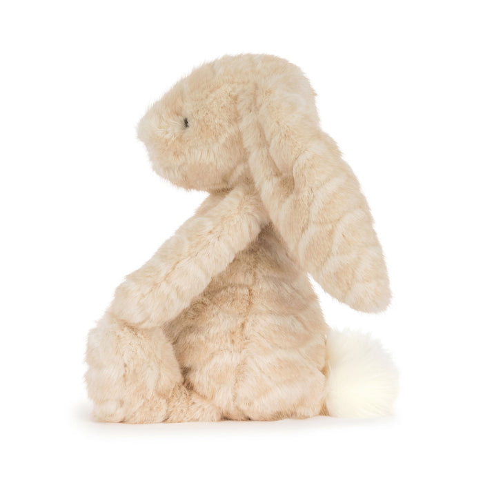 A plush stuffed bunny toy in a soft cream-beige color, sitting upright against a clean white background. - Image