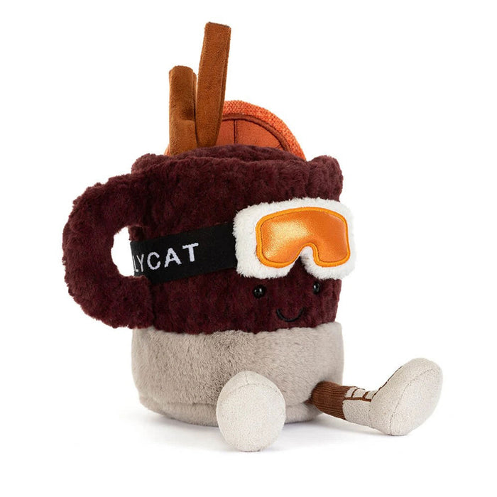 A plush toy shaped like a hot mulled Christmas drink mug with a smiling face, wearing orange goggles, sitting on a white background. - Image