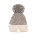 Side view of a soft toy wearing a grey Aran pom pom hat - Image