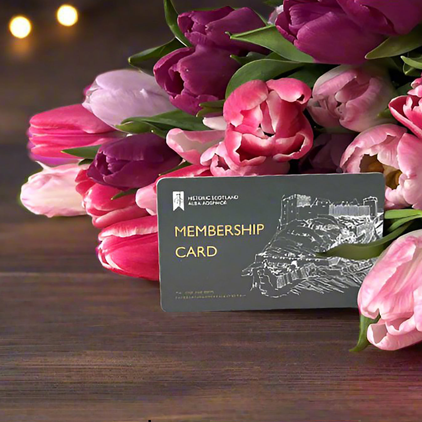 Membership card with pink and purple tulips on a wooden surface - Image