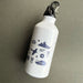 A white insulated water bottle with a black lid and metal carabiner, decorated with navy blue military-themed silhouettes including a ship, plane, tank, stars, and medals, shown on a textured gray background. - Image