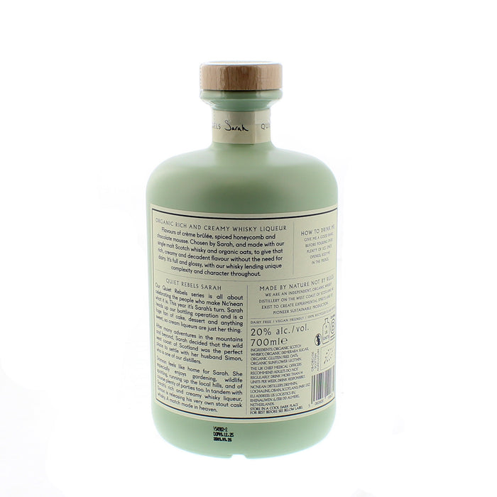 Back label on a mint green bottle of liqueur against a white background.  - Image