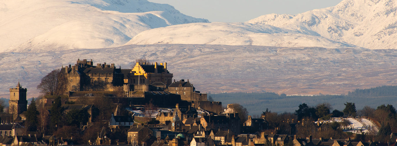 Stirling Castle surrounded by snow-capped mountains - Image