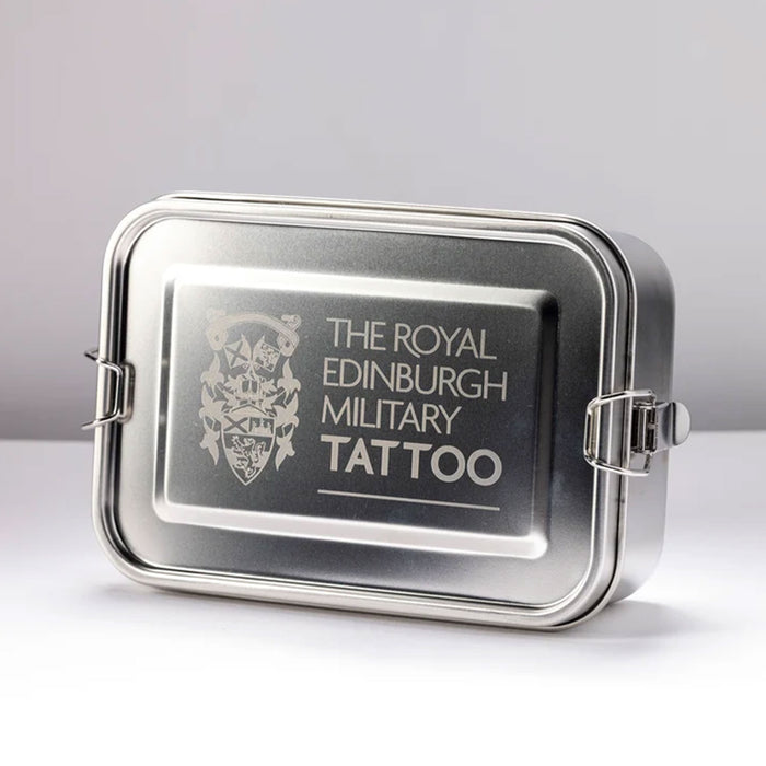 A rectangular stainless steel tin with a hinged lid, featuring an engraved silver emblem and the text 'THE ROYAL EDINBURGH MILITARY TATTOO' on the front, set against a neutral light gray background. - Image