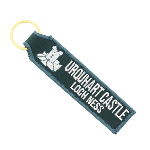 Dark green fabric keyring with gold hardware and white embroidered text reading 'URQUHART CASTLE LOCH NESS' and a design of the castle. - Image