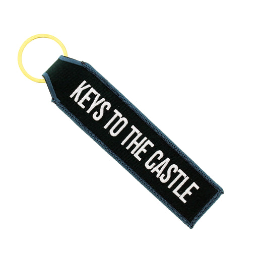 Dark green fabric keyring with gold hardware and white embroidered text reading 'KEYS TO THE CASTLE'. - Image