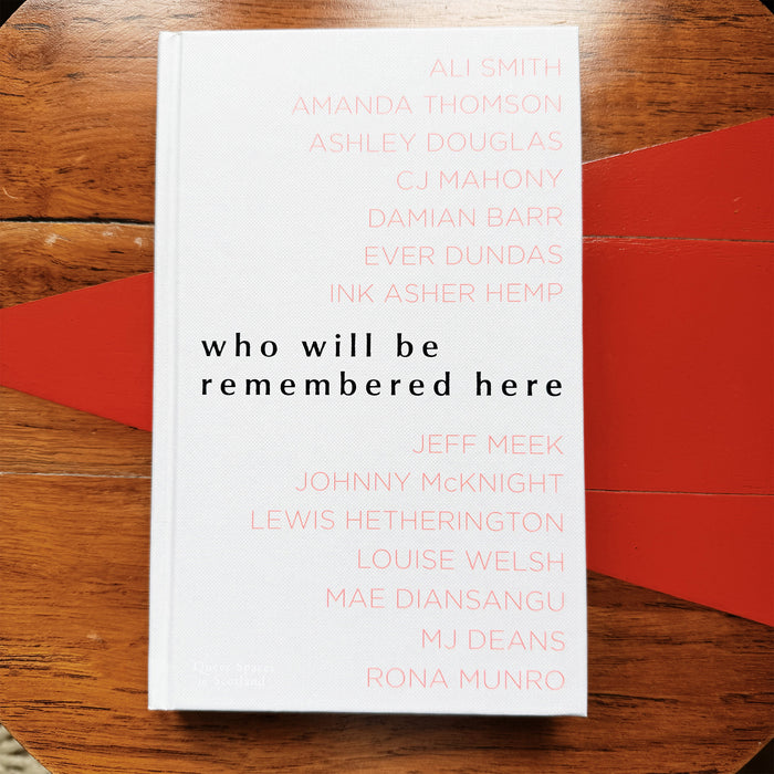 front cover of who will be remembered here on a round coffee table with red triangle design. - Image