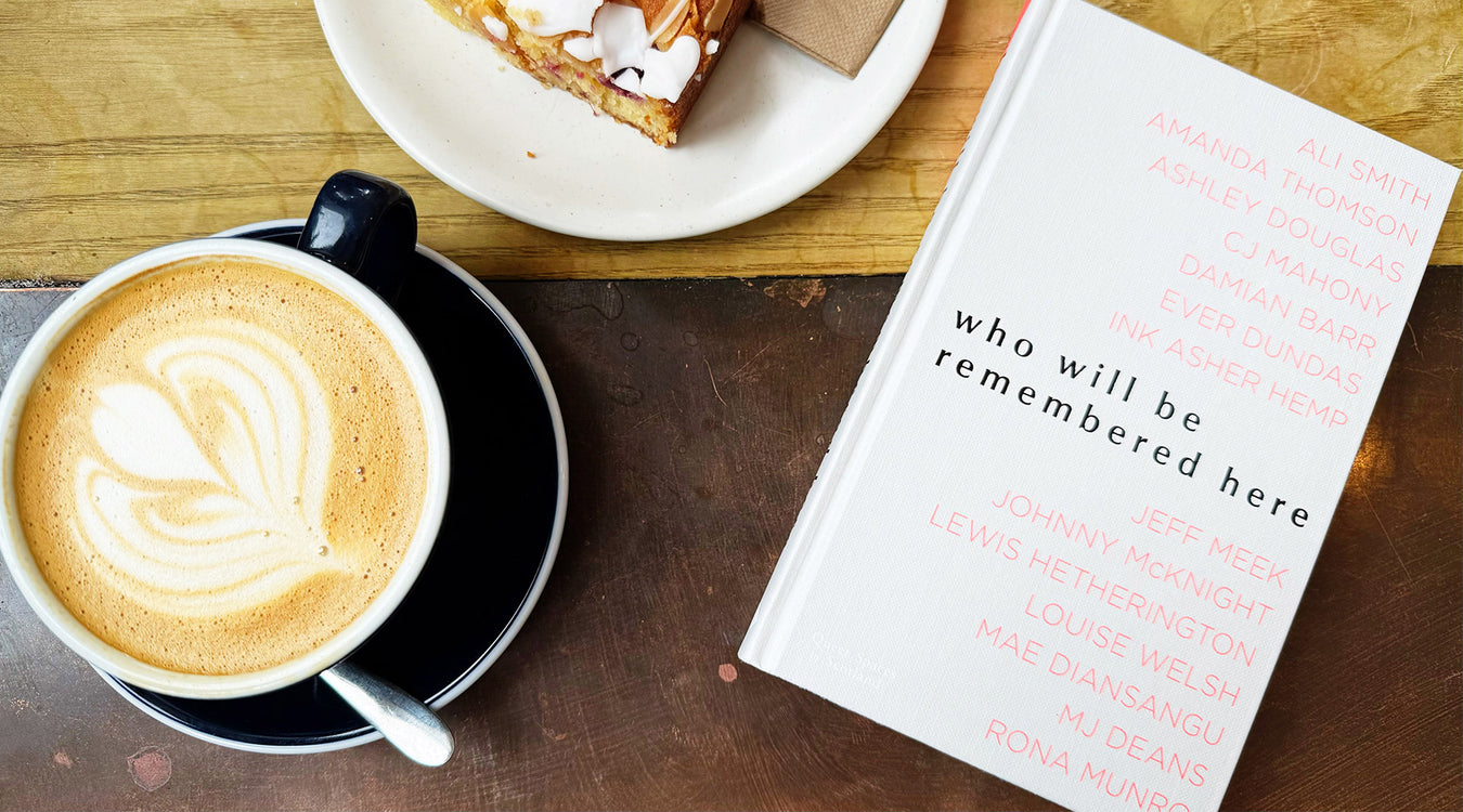 book titled 'who will be remembered here', and a pastry on a wooden table. - Image