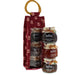 A gift set from Mrs Bridges featuring three glass jars of Christmas preserves stacked next to a red fabric pouch with a  ring handle.  - Image