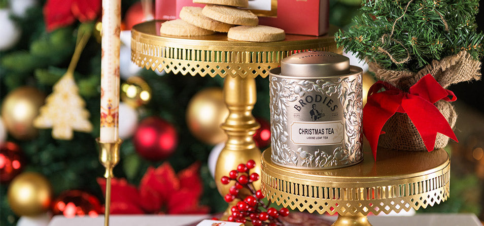 Gold Christmas Tea Tin surrounded by Scottish shortbread and festive decorations.  - Image