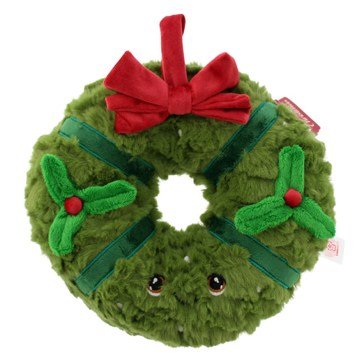 A plush green Christmas wreath toy with a red bow, green ribbon accents, holly details, and embroidered eyes, shown on a plain white background. - Image