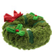 A plush green wreath-shaped soft toy faux fur texture, decorated with a large red bow and green holly leaves with red berries, shown on a plain white background. - Image