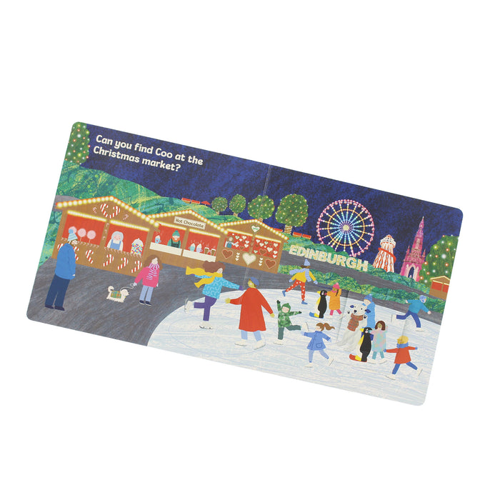 A rectangular illustrated card or print shown at an angle on a plain white background. The artwork depicts a festive winter market scene with people ice skating, Christmas stalls, trees, a ferris wheel, and the text 'Can you find Coo at the Christmas market?' and 'Edinburgh'. - Image