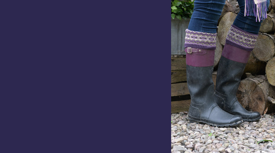 welly socks shown in wellies on a model in a garden closeup with logs and gravel in background