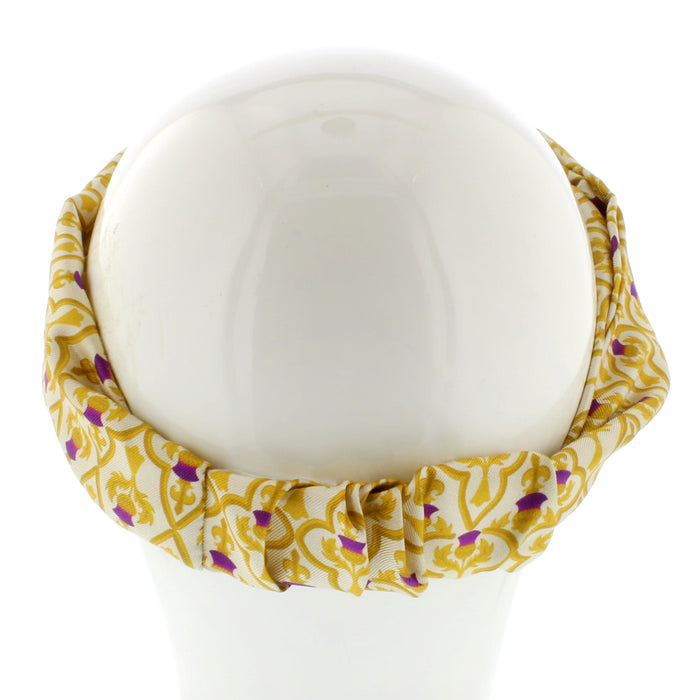 White mannequin head shows a thistle print headband in gold and purple 