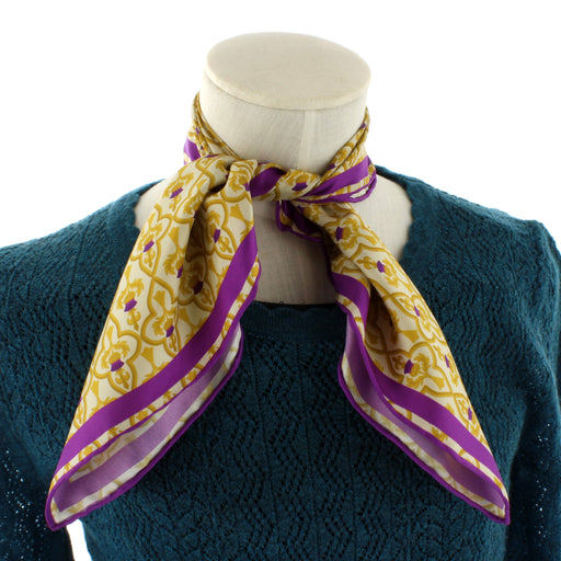 White mannequin showcasing the thistle print neck silk neck scarf in gold and purple