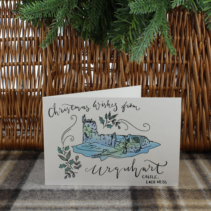urquhart castle christmas card shown with hamper and tartan blanket with pine tree over hanging