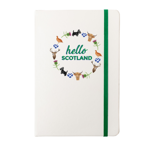 A beautiful designed white notebook with the words 'Hello Scotland' in green, featuring elements of Scottish culture and scenery. A green strap closes over the right hand side.