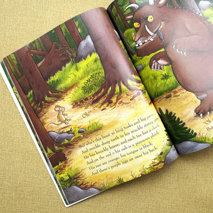 Illustrated book open to a page with a gruffalo and moose in a forest setting - Image