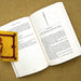 Open book with a yellow bookmark on a textured surface - Image
